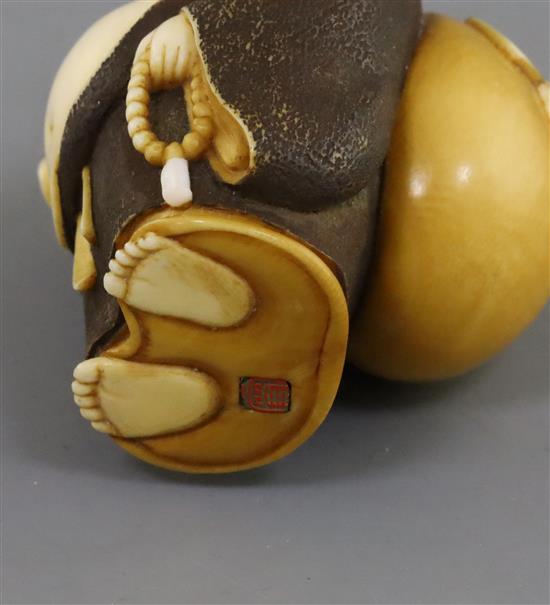 A Japanese ivory okimono netsuke of Hotei, early 20th century, H. 5.2cm